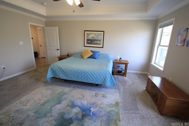 carpeted bedroom with a raised ceiling, crown molding, and ceiling fan