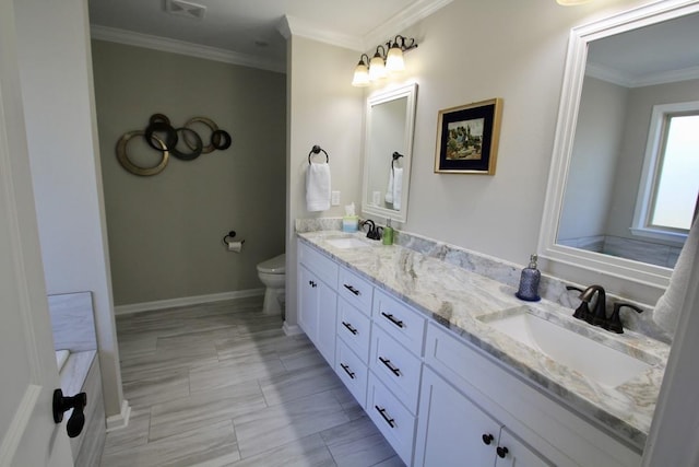 bathroom with vanity, crown molding, and toilet