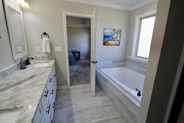 bathroom with vanity, crown molding, and tiled bath