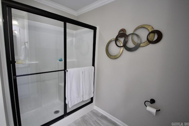 bathroom with ornamental molding and a shower with door