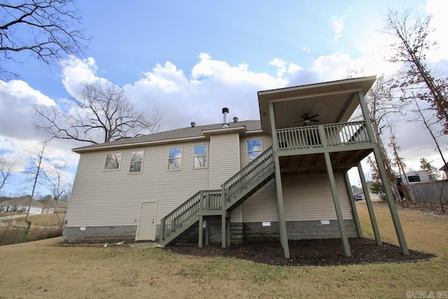 back of property with a wooden deck, a yard, and ceiling fan