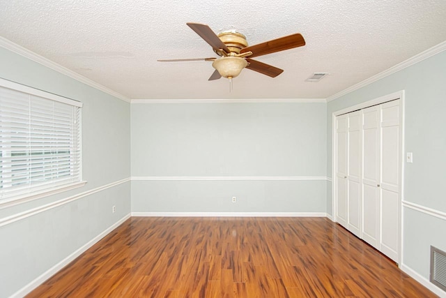 unfurnished bedroom featuring hardwood / wood-style flooring, ornamental molding, a closet, and a textured ceiling