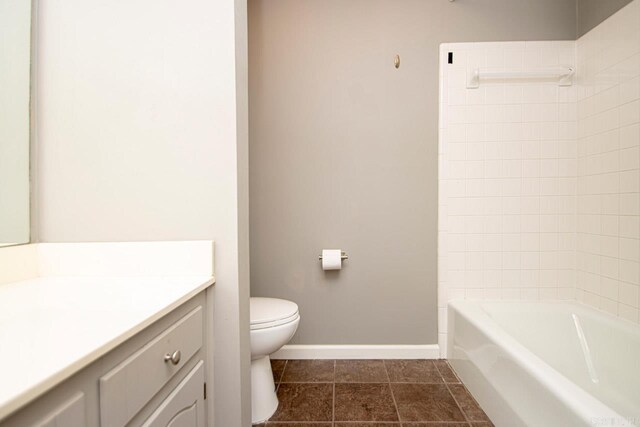 full bathroom with tiled shower / bath, vanity, toilet, and tile patterned flooring