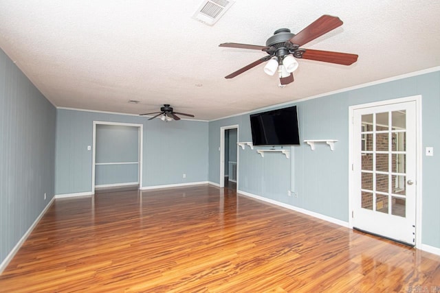 unfurnished living room with wood-type flooring, ceiling fan, a textured ceiling, and crown molding