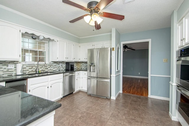 kitchen with sink, appliances with stainless steel finishes, backsplash, a textured ceiling, and white cabinets