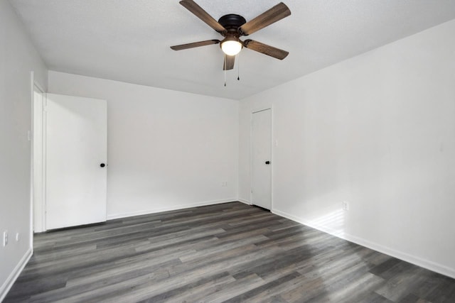 spare room featuring dark wood-type flooring, ceiling fan, and a textured ceiling