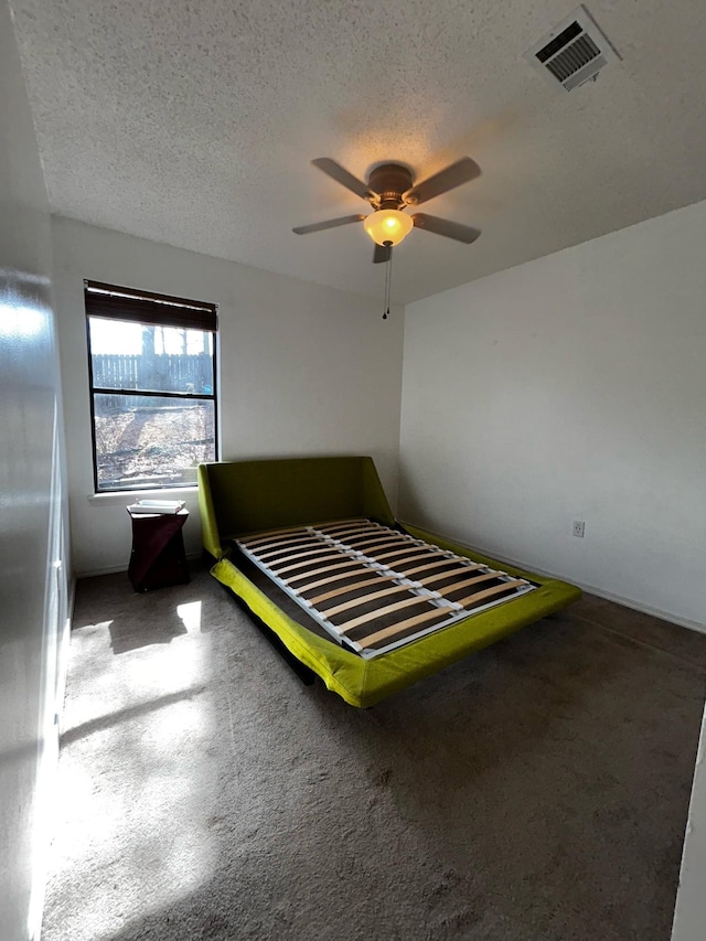 unfurnished bedroom featuring ceiling fan and a textured ceiling