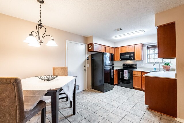 kitchen with sink, an inviting chandelier, black appliances, a textured ceiling, and decorative light fixtures