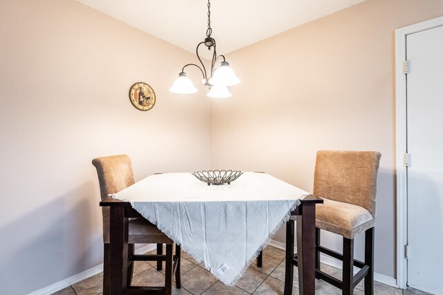 tiled dining room featuring a notable chandelier