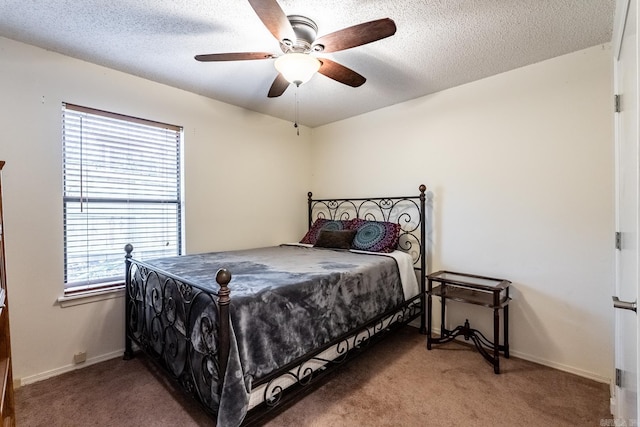 bedroom with ceiling fan, carpet floors, and a textured ceiling