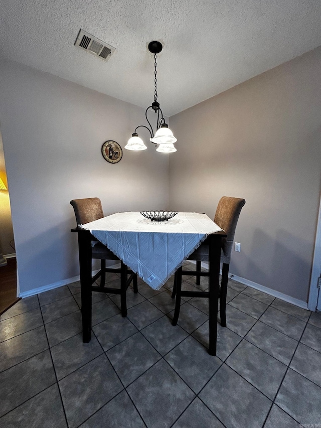 tiled dining area with a textured ceiling