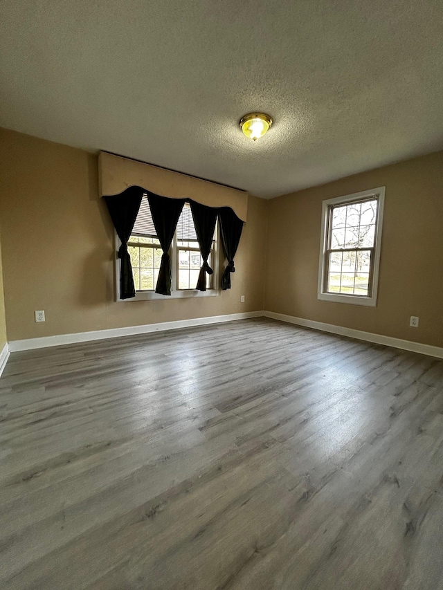 unfurnished room with wood-type flooring and a textured ceiling