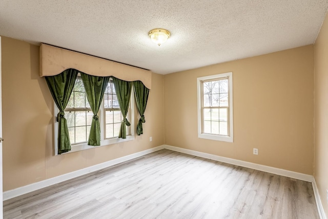 empty room featuring light hardwood / wood-style floors and a textured ceiling