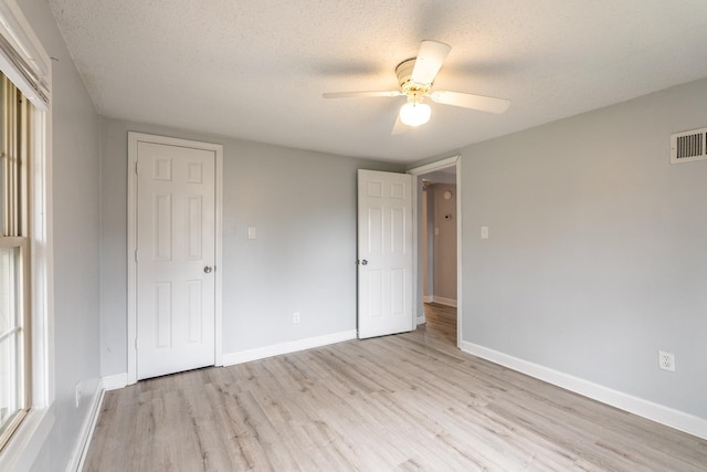 unfurnished bedroom with ceiling fan, light hardwood / wood-style floors, and a textured ceiling