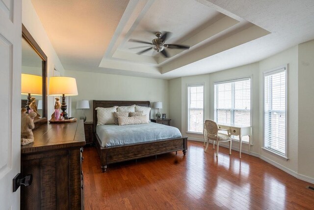 bedroom featuring a raised ceiling, hardwood / wood-style flooring, and ceiling fan