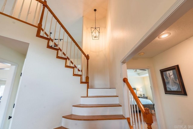 stairway featuring a towering ceiling