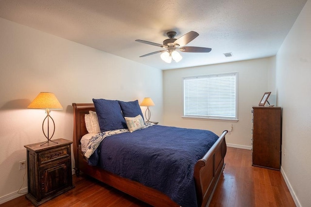 bedroom with dark hardwood / wood-style flooring and ceiling fan