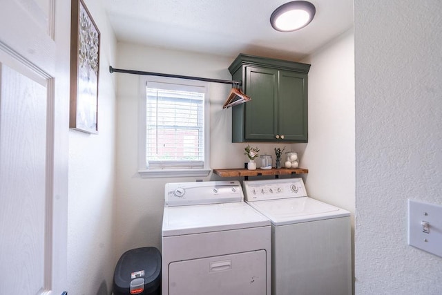 washroom with washer and dryer and cabinets