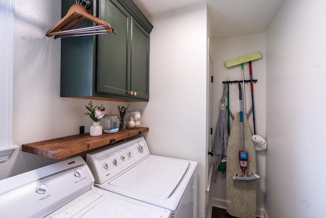 clothes washing area featuring cabinets and separate washer and dryer