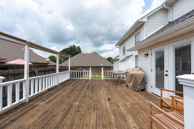 wooden deck featuring french doors and a grill