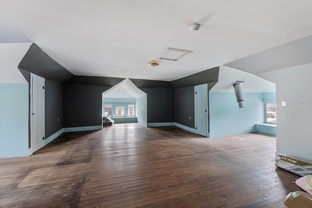 additional living space with hardwood / wood-style flooring and vaulted ceiling