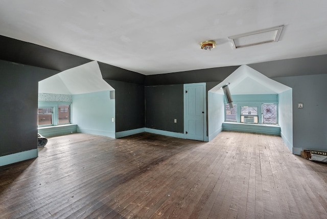 additional living space with wood-type flooring and vaulted ceiling