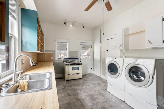 laundry area featuring sink, track lighting, washing machine and clothes dryer, and ceiling fan