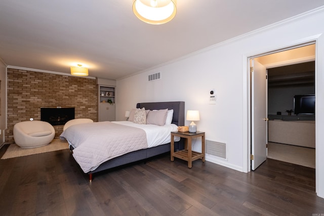 bedroom featuring crown molding, a fireplace, and dark hardwood / wood-style floors