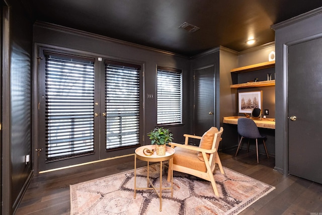 office space featuring crown molding, dark hardwood / wood-style floors, and built in desk