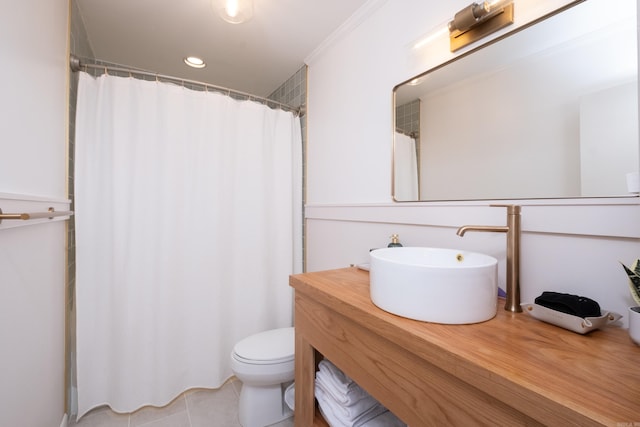 bathroom with tile patterned flooring, crown molding, vanity, and toilet