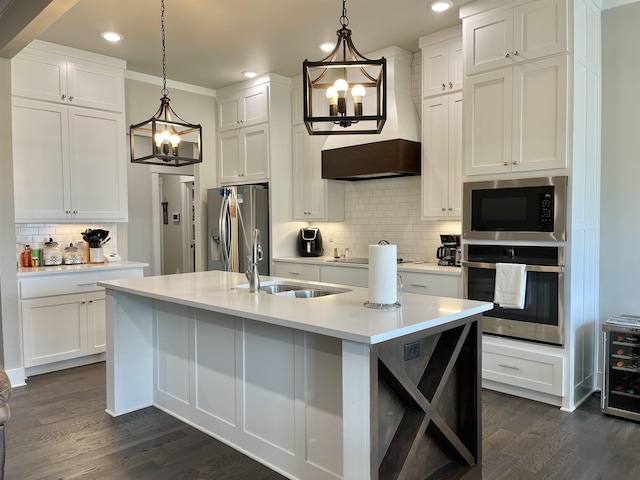 kitchen featuring decorative light fixtures, light countertops, appliances with stainless steel finishes, white cabinets, and a sink