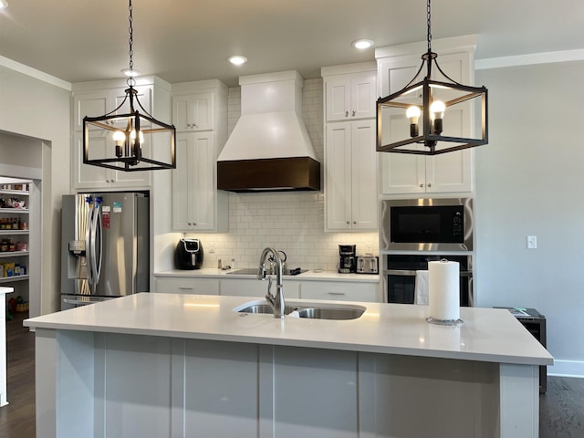 kitchen featuring decorative light fixtures, custom exhaust hood, stainless steel appliances, and an island with sink