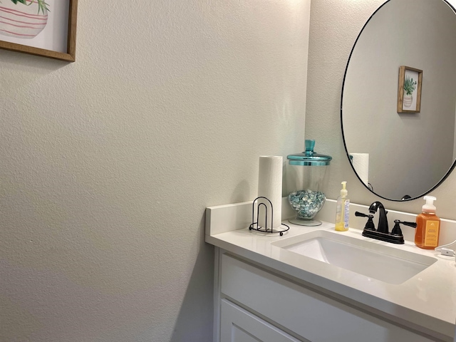 bathroom with a textured wall and vanity