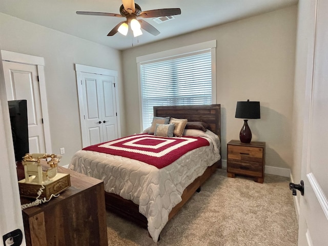 bedroom featuring light carpet, a closet, a ceiling fan, and baseboards