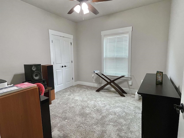 office space featuring light carpet, ceiling fan, and baseboards