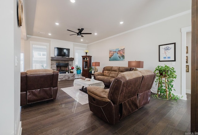 living room with dark wood-style floors, a fireplace, ornamental molding, and recessed lighting