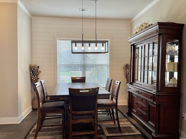 dining room with dark hardwood / wood-style flooring, wooden walls, and ornamental molding