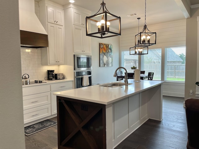 kitchen with premium range hood, sink, white cabinets, a kitchen island with sink, and stainless steel appliances