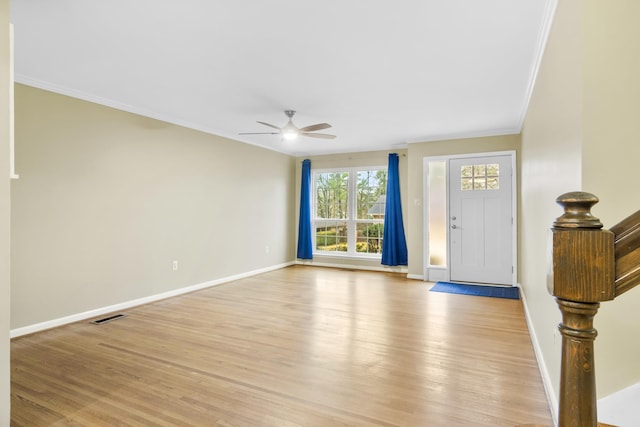 foyer featuring ceiling fan, ornamental molding, and light wood-type flooring