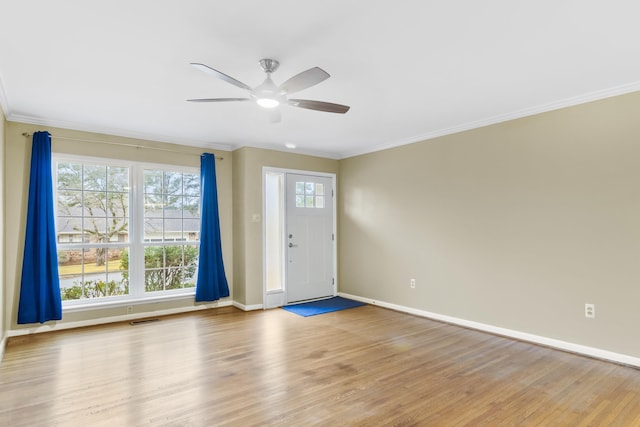 foyer entrance with ornamental molding, ceiling fan, and light wood-type flooring