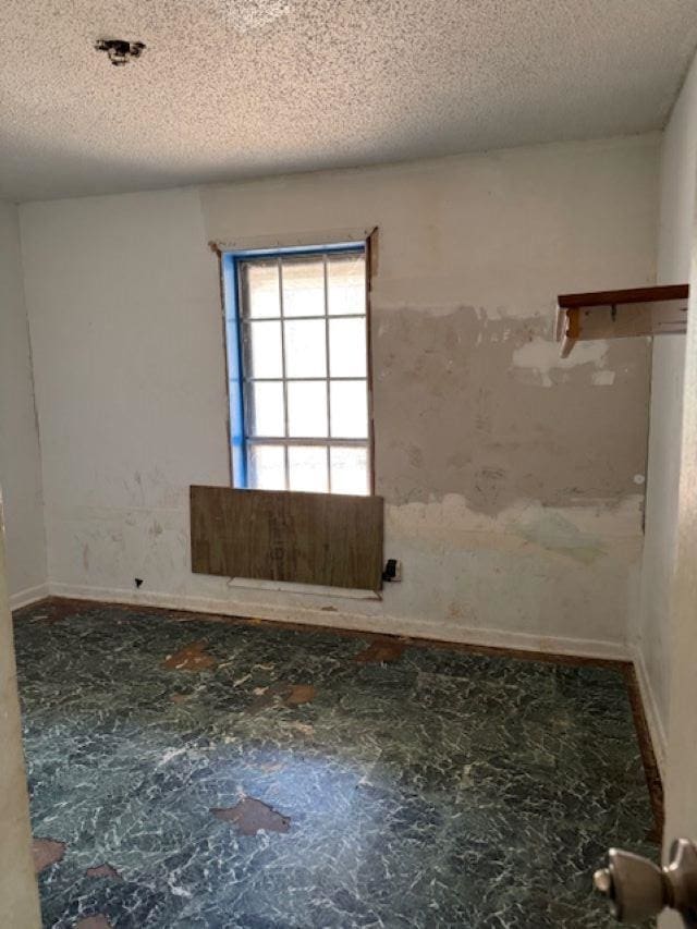 unfurnished room featuring a textured ceiling