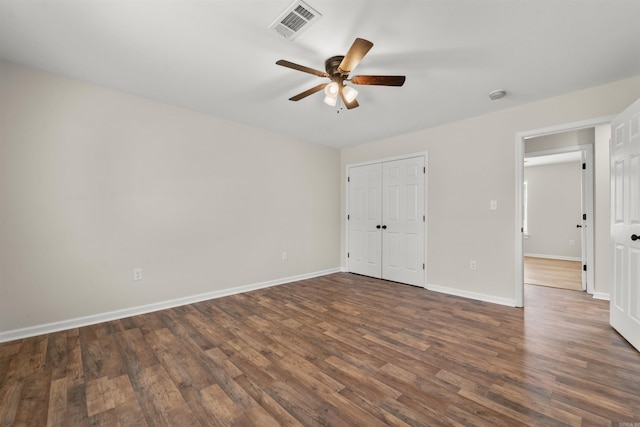 unfurnished bedroom featuring dark wood-type flooring, ceiling fan, and a closet