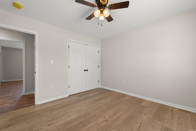 unfurnished bedroom with ceiling fan, light wood-type flooring, and a closet