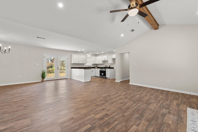 unfurnished living room with hardwood / wood-style flooring, ceiling fan with notable chandelier, and lofted ceiling with beams