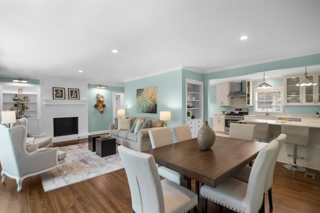 dining space with built in shelves, dark hardwood / wood-style floors, and sink