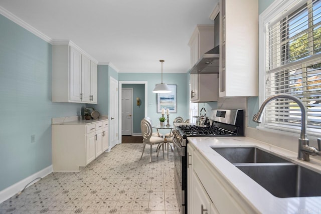 kitchen featuring decorative light fixtures, stainless steel gas stove, white cabinetry, sink, and ornamental molding