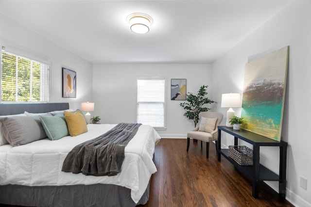 bedroom with multiple windows and dark hardwood / wood-style flooring