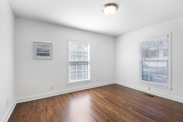 empty room with dark hardwood / wood-style flooring