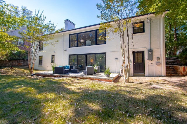 rear view of property featuring an outdoor living space, a yard, and a patio area