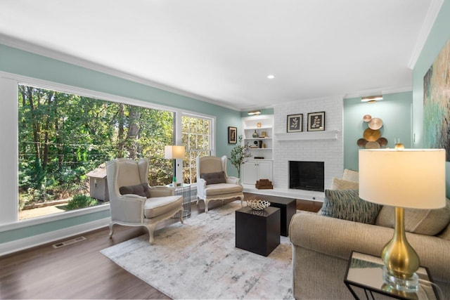 living room featuring a fireplace, hardwood / wood-style flooring, a wealth of natural light, and ornamental molding